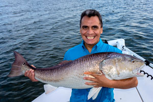Angler holding a huge redfish in Mosquito Lagoon
