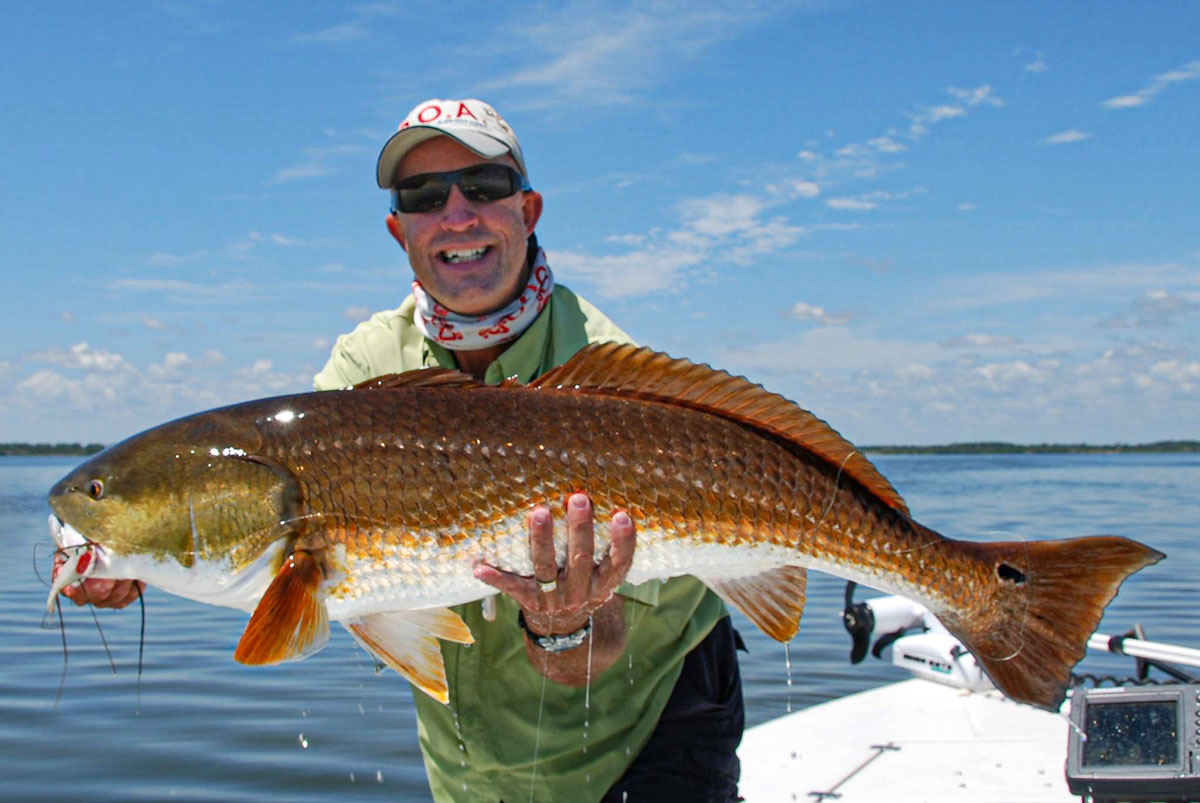 Capt. Chris Myers holding a redfish on Mosquito Lagoon